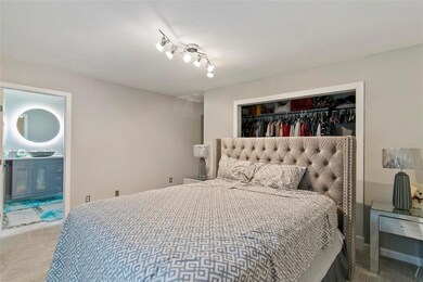 Primary bedroom featuring rail lighting, updated e