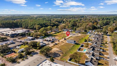 Aerial view of The Villages at Withers Heights and surrounding areas with a forest and nearby areas.