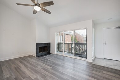 Inviting living room featuring a wood-burning fireplace and direct access to a private balcony.