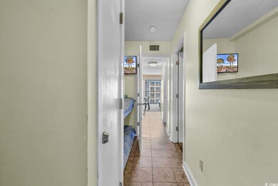 Hall with tile patterned flooring, baseboards, and