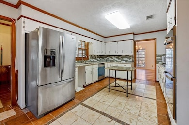 Kitchen featuring sink, white cabinetry, appliance