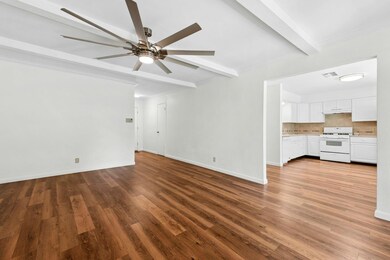 Unfurnished living room with beamed ceiling, a ce