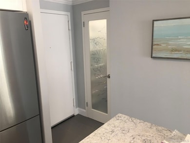 Bathroom featuring dark tile patterned flooring and crown molding