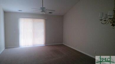Large great room with vaulted ceilings and door to