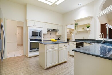 Kitchen with a center island, light carpet, sink, stainless steel dishwasher, and cream cabinetry