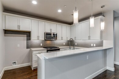 Kitchen with white cabinets, appliances with stain
