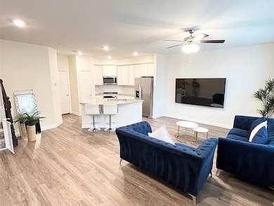Living area featuring baseboards, light wood-style