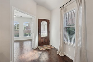 Entryway featuring dark wood floors, lofted ceiling, and ceiling fan
