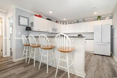 Kitchen with white appliances, a peninsula, crown 