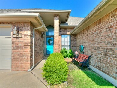 View of exterior entry featuring an attached garage, brick siding, and roof with shingles