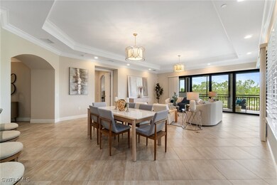 Dining room featuring a raised ceiling, arched wal