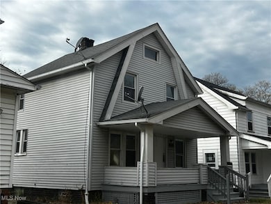 View of side of home featuring covered porch, a chimney, and a shingled roof