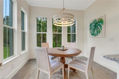 Dining space with plenty of natural light, a chandelier, light wood-style floors, and baseboards