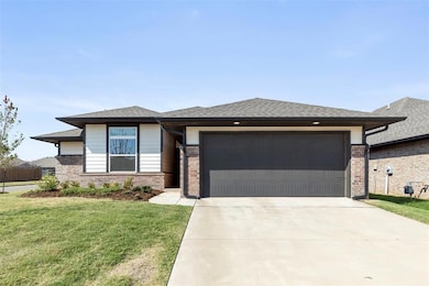 Prairie-style home with a front lawn, roof with shingles, concrete driveway, and brick siding