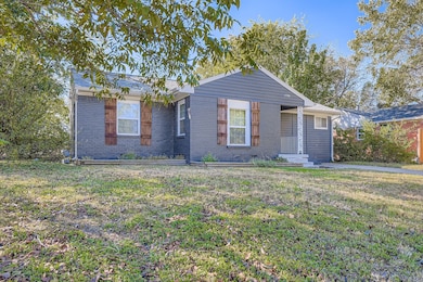 View of front of house with brick siding and a front lawn