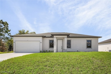 View of front of home with a front yard and a gara
