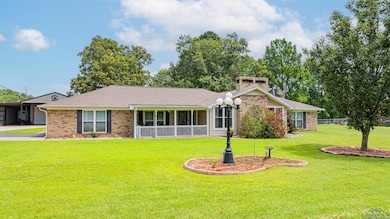 View of front of house with a front yard, brick siding, and a chimney