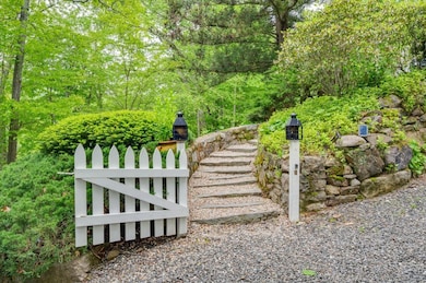 Entry gate from the driveway with a gravel and stone path leading to the house.