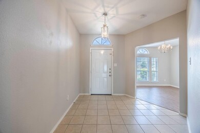 Tiled entrance foyer with a chandelier