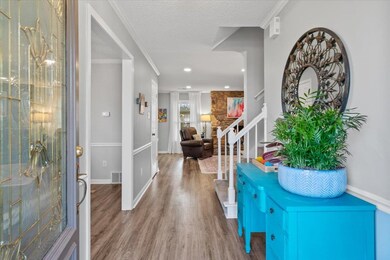 Entrance foyer with crown molding, stairway, a tex
