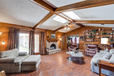 Living room featuring wooden walls, a gas fireplac