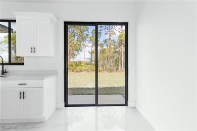Doorway to outside featuring marble look tile flooring and baseboards