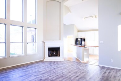 Unfurnished living room featuring track lighting, high vaulted ceiling, and light hardwood / wood-style flooring