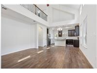 Unfurnished living room featuring a towering ceil