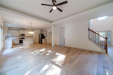 Unfurnished living room with light wood-style floors, stairway, and ceiling fan