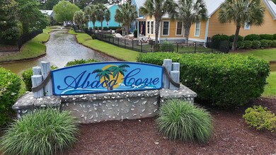 Community sign featuring fence and a water view