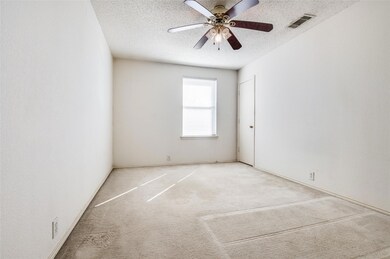 Carpeted spare room featuring a ceiling fan, visib
