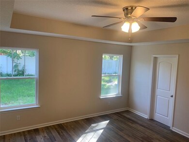 Master Bedroom featuring trayed ceiling and wood l