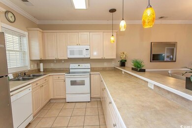 Kitchen featuring pendant lighting, white applianc