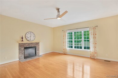 Family room with hardwood floors, stone fireplace, beautiful view of wooded back yard
