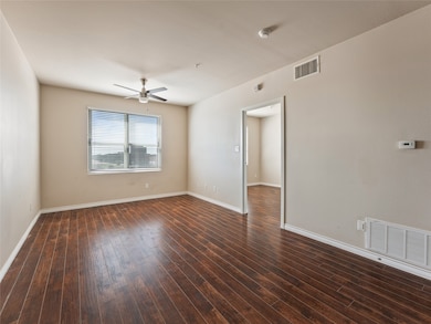 Unfurnished living room with dark wood-type flooring and a ceiling fan