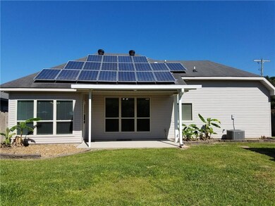 Rear view of home with solar panels making this ho