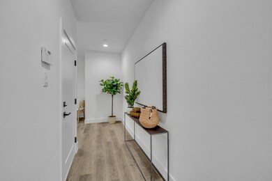 Hallway with baseboards, light wood-type flooring,
