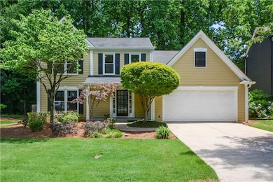 View of front of house featuring concrete driveway, a front yard, a garage, and covered porch