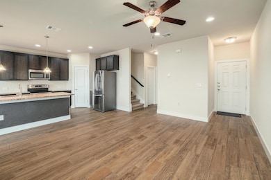 Kitchen featuring a ceiling fan, a sink, stainles