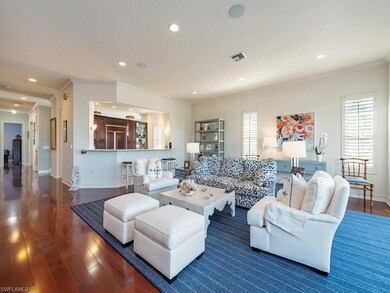 Living room with ornamental molding, recessed lighting, and dark wood-style flooring