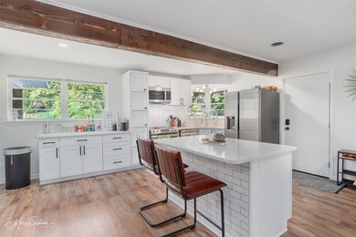 Kitchen with white cabinets, appliances with stain