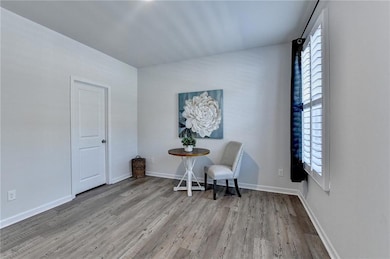 Sitting room featuring baseboards, wood finished f