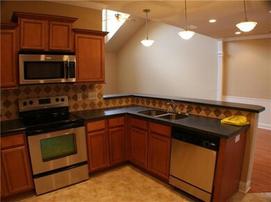 Gorgeous kitchen with stainless steel appliances, under cabinet lighting,   tumble stone back splash, smooth top stove, and solid surface counter tops.   Also features a great raised bar for informal eating.