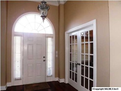 Inviting Foyer with 12' Ceiling, Hardwood Floors and Crown Moulding. French doors open to Living Room/Study