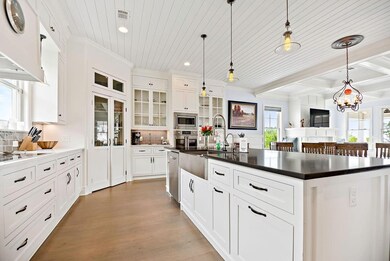 Another view of kitchen. Glass front pantry, touch