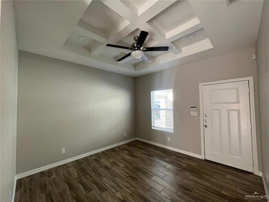 Unfurnished room with coffered ceiling, dark wood-style flooring, baseboards, beamed ceiling, and a ceiling fan