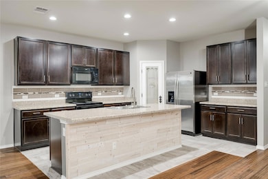 Kitchen with black appliances, a sink, decorative