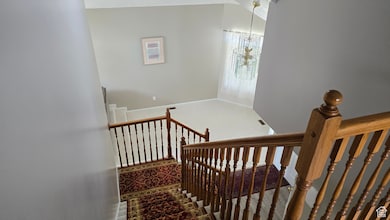 Stairway featuring carpet and a chandelier