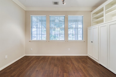 The Study/Office features built in cabinetry and shelving, double crown moulding, neutral paint, and wood laminate floors