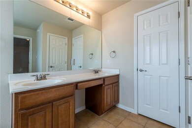 Bathroom with double vanity and tile patterned fl